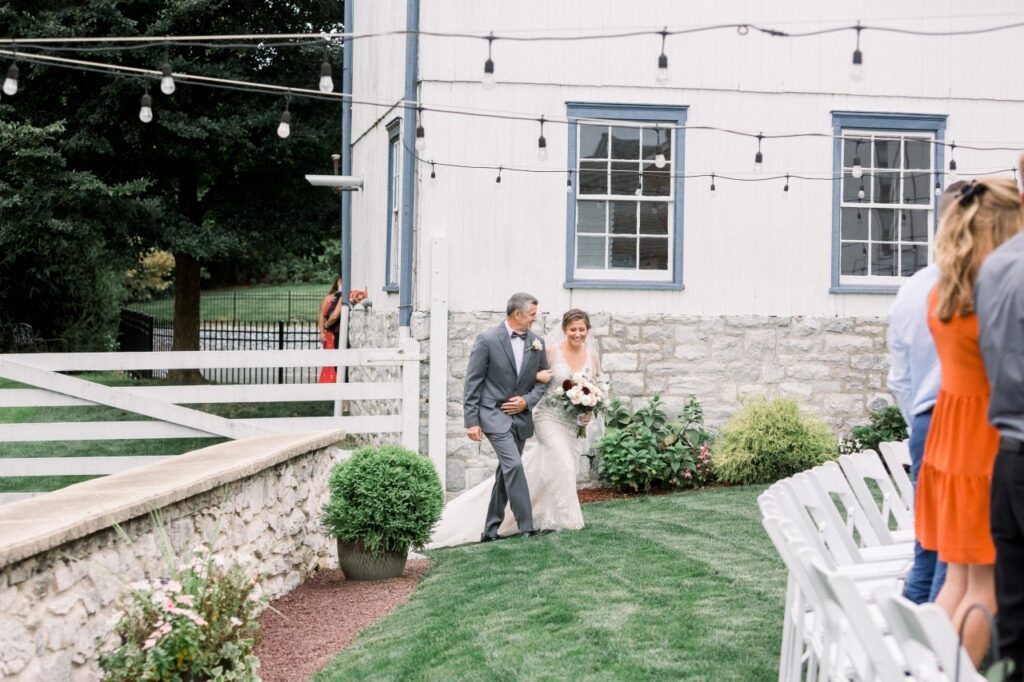 bride being walked down the aisle in an outdoor wedding venue